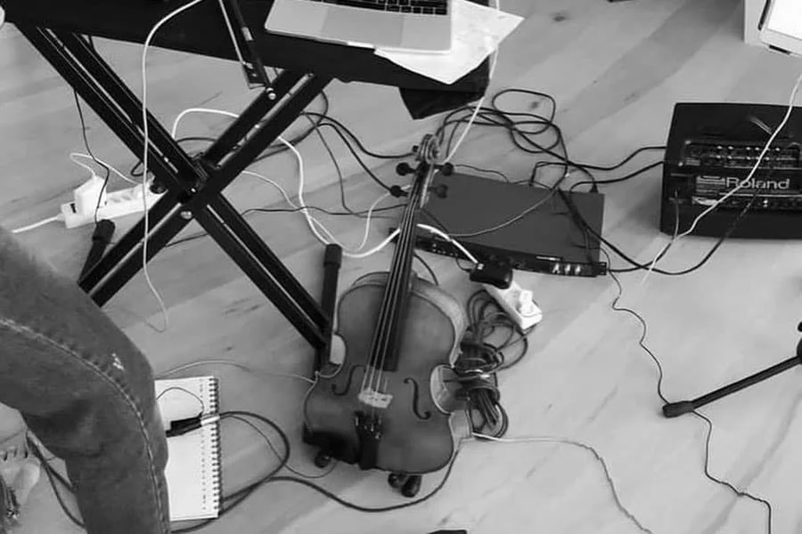 Viola, cables and live-electronics gear on a studio floor